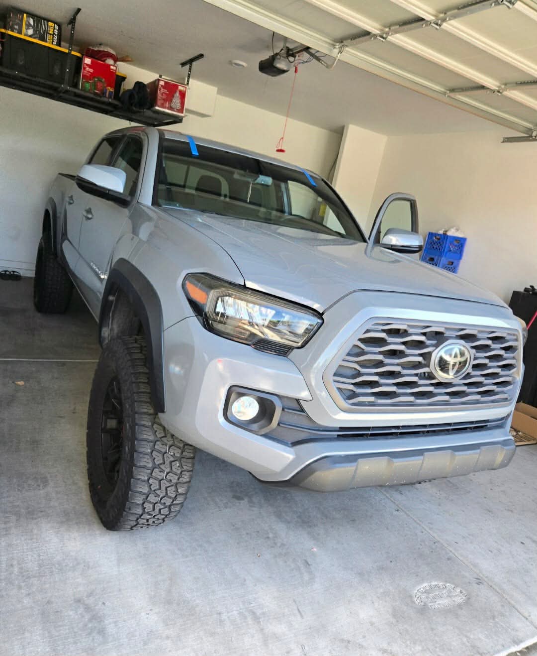 Silver Toyota Tacoma TRD with a freshly installed windshield in a customer's garage.